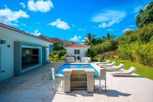 a patio with chairs and a table and a pool at Villa 107 in Sosúa