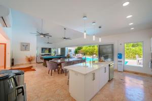 a kitchen and living room with a table and a pool at Villa 107 in Sosúa