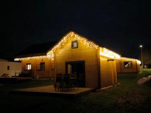 a house covered in christmas lights at night at Charmant petit chalet jurassien in Saint-Lamain