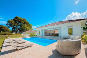 a villa with a swimming pool and a house at Villa 107 in Sosúa