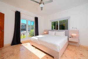 a white bedroom with a large bed and a window at Villa 107 in Sosúa +90 photos