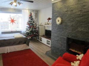 a living room with a christmas tree and a fireplace at Piriko Apartments in Rovaniemi