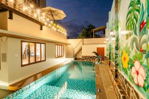 a swimming pool with a mural on the side of a building at Gió Villa in Ấp Sơn Hải