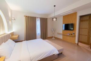 a hotel room with a bed and a flat screen tv at Gió Villa in Ấp Sơn Hải