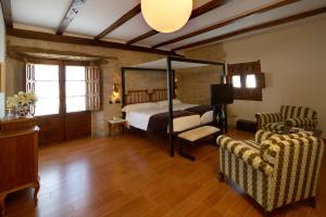 a bedroom with a canopy bed and two chairs at Concejo Hospederia in Valoria la Buena