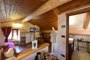a living room with a wooden ceiling and a bedroom at L'Ancien Paquier Chambre D'Hotes in Valtournenche