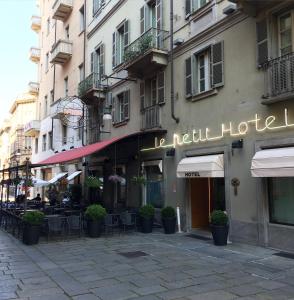 a building with a hotel sign on a street at Le Petit Hotel in Turin