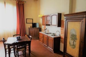 a kitchen with wooden cabinets and a wooden table at Agriturismo Antico Borgo Poggitazzi in Loro Ciuffenna