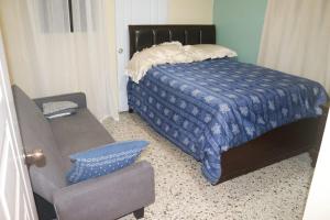 a bedroom with a bed and a couch and a chair at Terraza Marina in Bajos de Haina
