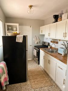 a kitchen with a black refrigerator and a sink at Terraza Marina in Bajos de Haina