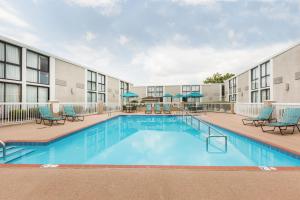 una piscina en un hotel con sillas y un edificio en Wyndham Riverfront Hotel, en Little Rock