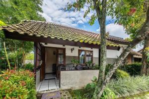 a small house with a patio and trees at Dedaunan Guesthouse in Tlekung