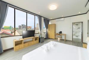 a bedroom with a large bed and a tv at Peaceful 2 Hotel in Vientiane +31 photos