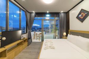 a bedroom with a large bed and a television at Peaceful 2 Hotel in Vientiane