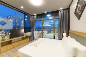 a bedroom with a bed and a large window at Peaceful 2 Hotel in Vientiane