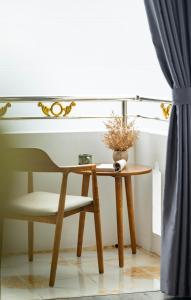a table and a chair next to a window at Peaceful 2 Hotel in Vientiane