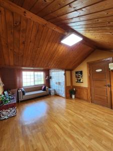 a large living room with a couch and wooden ceilings at 버킷 제주 - Bucket Jeju in Seogwipo