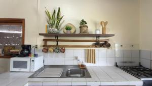 a kitchen with a sink and a microwave at Casa independiente in Puerto Ayora