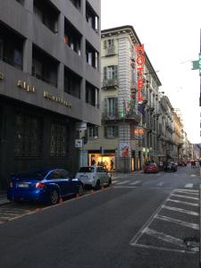 a city street with cars parked in front of buildings at Le Petit Hotel in Turin