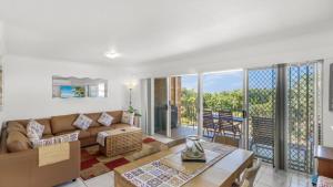 a living room with a couch and a balcony at The Calm At Moreton View in Woorim