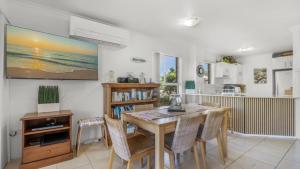a dining room with a table and chairs at The Calm At Moreton View in Woorim +15 photos