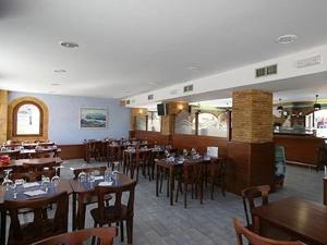 un comedor con mesas y sillas en un restaurante en Hostería Isla Cabrera, en Suances