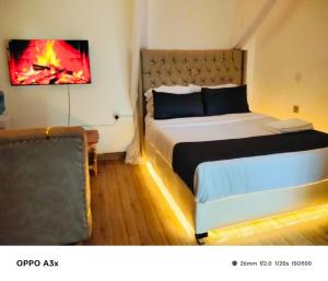 a bedroom with a bed with a fire painting on the wall at Marine waters retreat Block A in Embu
