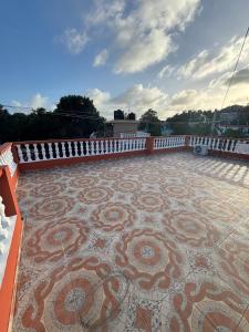 a patio with a mosaic floor and a white fence at Terraza Marina in Bajos de Haina +2 photos
