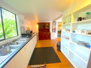 a kitchen with a sink and a counter top at Lakeside 3-BR Forest Cottage in Laurieton