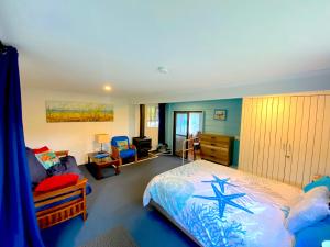 a bedroom with a bed and a couch at Lakeside 3-BR Forest Cottage in Laurieton