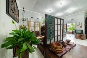 a living room with a table and a plant at Dedaunan Guesthouse in Tlekung