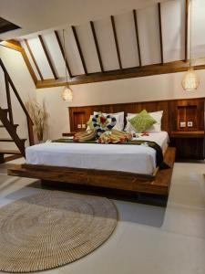 a bedroom with a large bed with a wooden frame at Lucy's Garden Hotel in Gili Islands