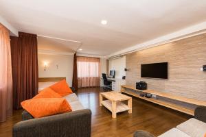un salon avec un canapé et une télévision à écran plat dans l'établissement City Center Studio Apartment, à Tallinn 2 autres photos
