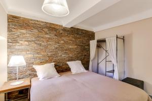 カンヌにあるFlorella Félix Faureのレンガの壁とベッドが備わるベッドルーム1室が備わります。
