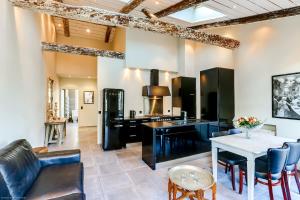 Una cocina con electrodomésticos negros y una mesa con sillas. en Florella Félix Faure, en Cannes