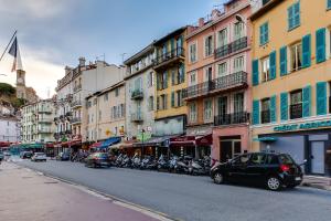 una calle de la ciudad con coches y motocicletas aparcados en la calle en Florella Félix Faure, en Cannes