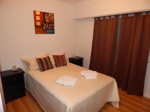 1 dormitorio con 1 cama con 2 toallas en Departamento Sierras Pampas en Tandil