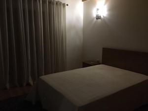 a bedroom with a bed and a light on the wall at Casa de Basto in Celorico de Basto