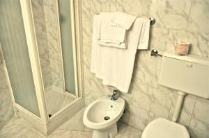 a bathroom with a shower and a toilet and towels at Hotel Vecchia Milano in Milan