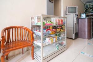 a chair sitting in front of a refrigerator at RedDoorz near Universitas Merdeka Malang 2 in Malang