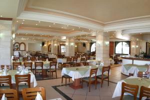 ein Esszimmer mit weißen Tischen und Stühlen in der Unterkunft Valley View Hotel - Hammana in Ḩammānā