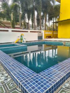 a swimming pool with blue tiles on the side of a building at Neon Villa in Pondicherry +17 photos