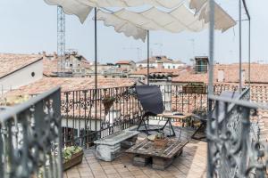 a balcony with a chair and an umbrella at Three Terraces in Venice