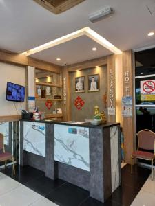 a lobby of a restaurant with a counter and chairs at Intanova Hotel in Teluk Intan