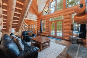a living room with a leather couch and a table at Fiddler Lake Resort - Bear 22 in Mille-Isles