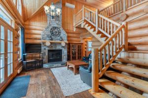 a spiral staircase in a log cabin with a fireplace at Fiddler Lake Resort - Bear 22 in Mille-Isles
