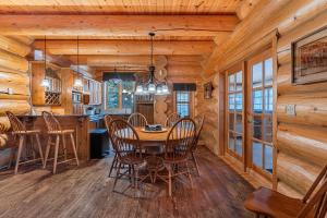 a dining room and kitchen in a log cabin at Fiddler Lake Resort - Bear 22 in Mille-Isles