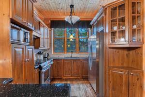 a kitchen with wooden cabinets and a stainless steel refrigerator at Fiddler Lake Resort - Bear 22 in Mille-Isles +17 photos