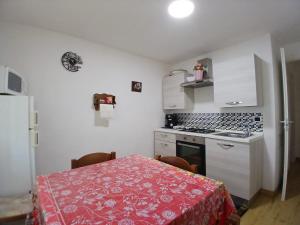 a kitchen with a table with a red table cloth at Cascina Danila in Narzole