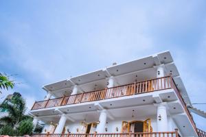 a white building with a balcony at King Palace Mirissa in Mirissa
